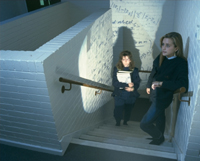 Students standing on the stairs with mathematical formulas projected on the walls.